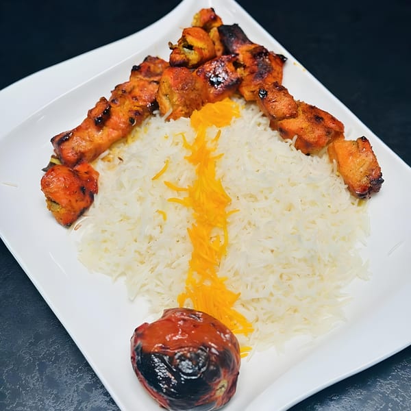 Emran Restaurant's chicken tikka kebab with white rice, saffron, and a grilled tomato.