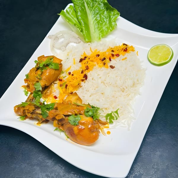 Emran Restaurant's Afghan chicken drumsticks with rice, topped with saffron, barberries, and a lime slice.